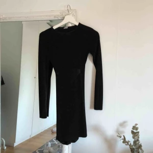  - Svart klänning uppen i ryggen och räfflad