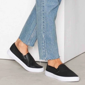 - Ett par svarta slip on sneakers i strl 40 från NLY Shoes. Använda endast ett fåtal ggr så de är i extremt fint skick. Nypriset var 200 SEK men jag säljer nu för mer än halva priset. Vid betalning: möts upp, tar endast Swish.