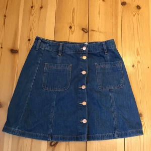  - 70:tals-inspirerad jeanskjol från hm. Använd en gång. Supersnygga knappar hela vägen ner och två fickor. 