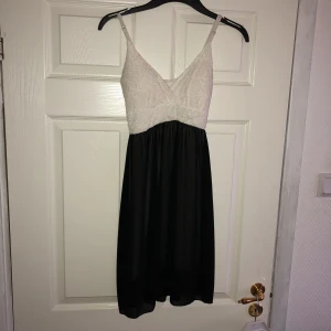  - Fin kort klänning i vit/svart med smala axelband. Inköpt i en butik utomlands. Använd enstaka gång. Det svarta tygets längd är 55 cm. Storlek M/L. Ev frakt 19kr 🌿