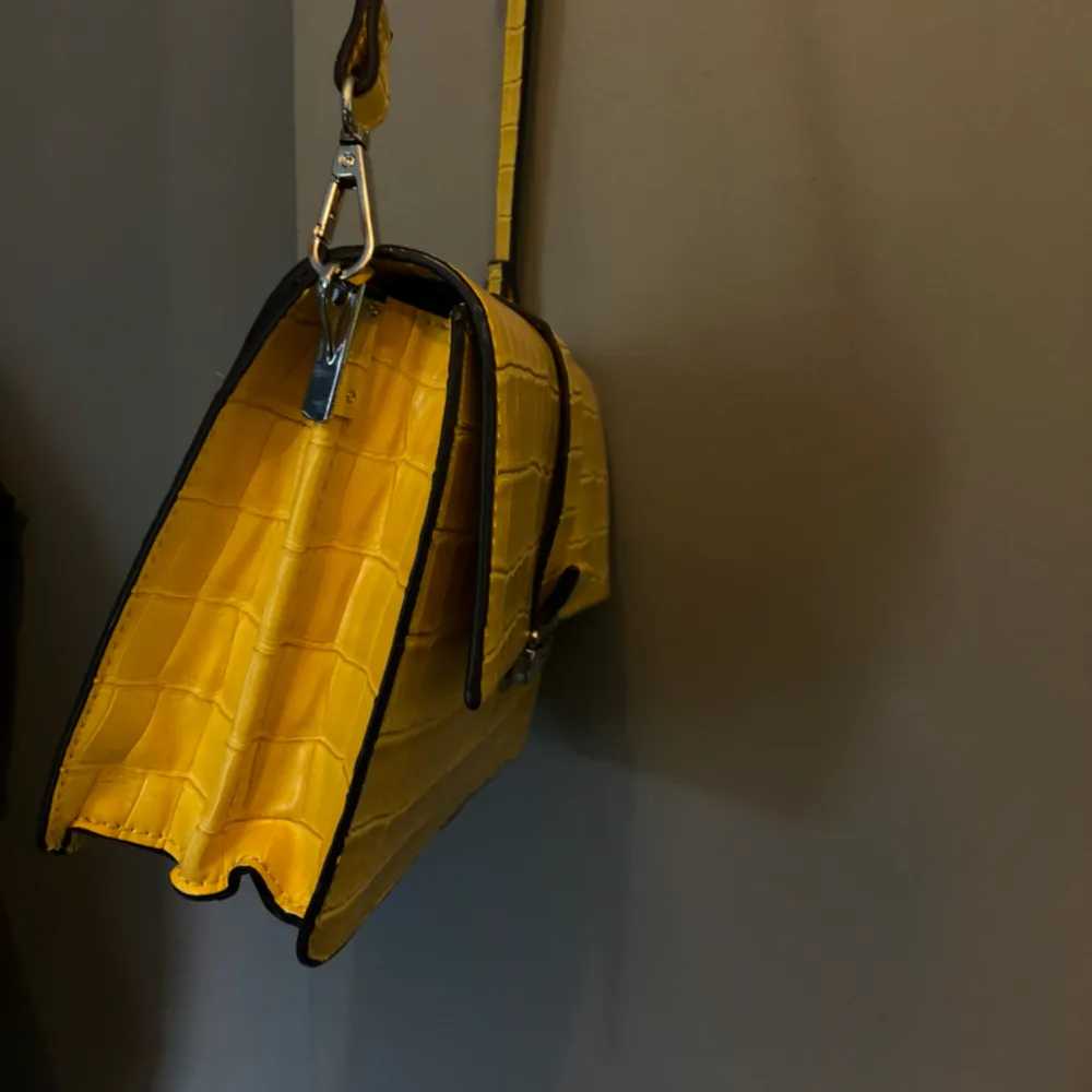 En gul väska från mango. Har använt några gånger men den är ett bra skick. Väskan går till revbenshöjd men längden går att ändra. . Väskor.