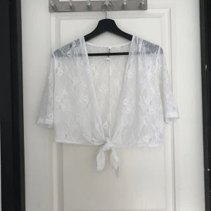  - Vit liten kofta i spets som går att knyta i midjan. Köpt på second hand. Bra skick.  Kan mötas upp i Mariestad, annars bjuder jag på frakten.  