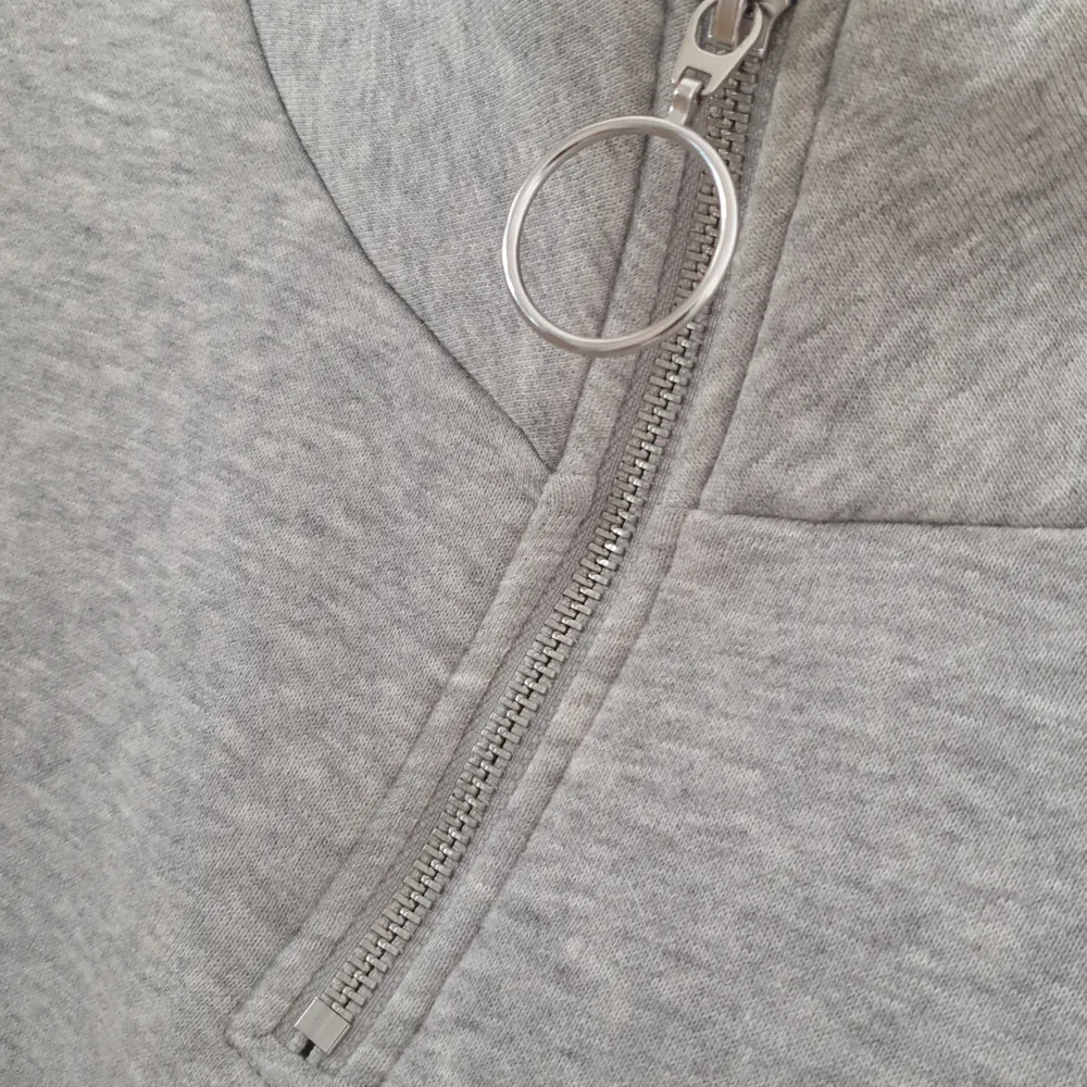 En grå collage tröja/hoodie med dragkedja och tryck. Mycket bra skick använd fåtal gånger . Tröjor & Koftor.