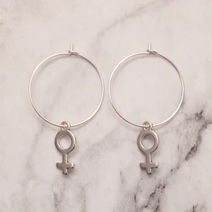 Hoops med kvinnosymbol *Liten* - Fina silverfärgade örhängen med kvinnosymbolen. Liten symbol. Finns även med större symbol. Se bild nr 3 för storleksskillnad. Nickelfria. 