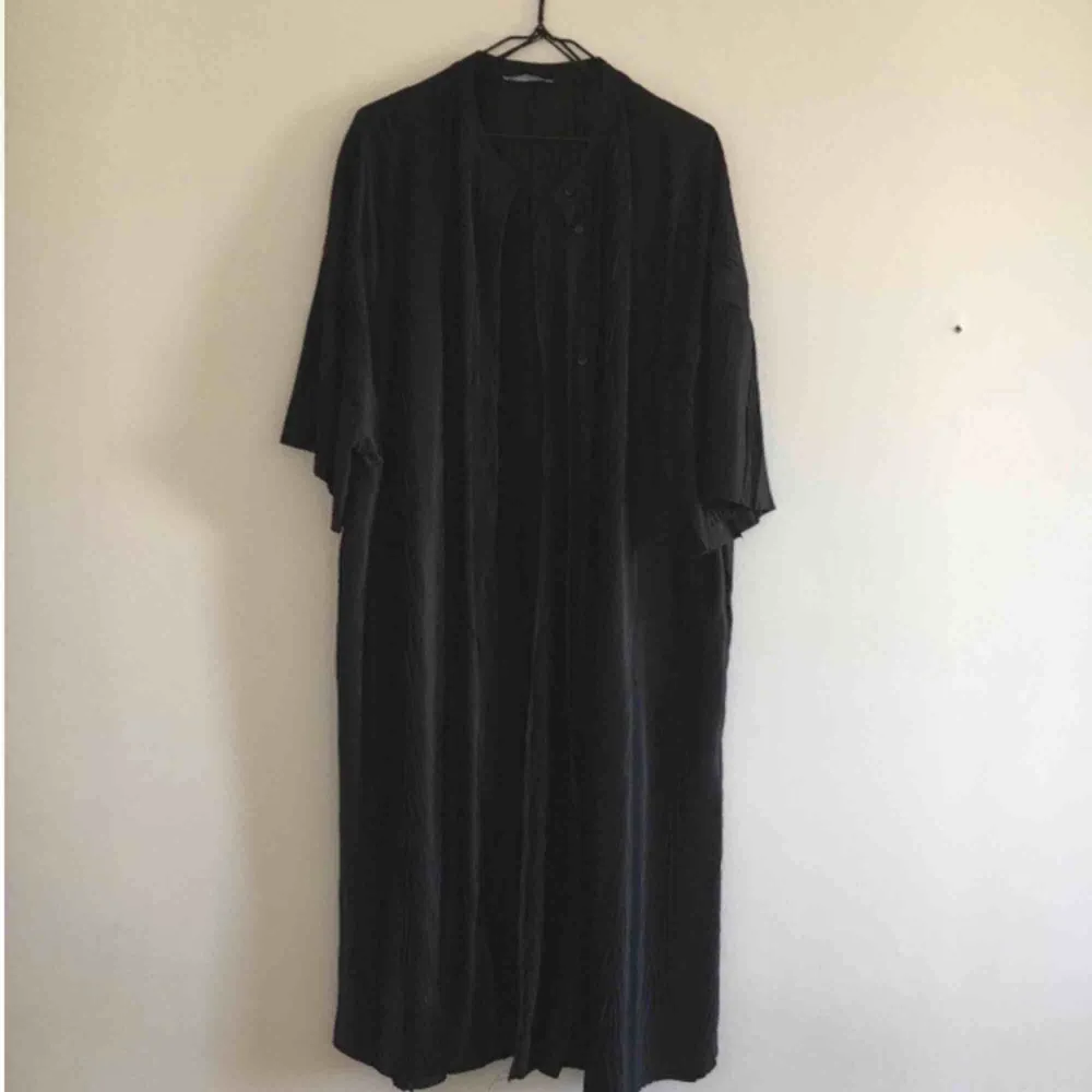 Kaftan/kimono köpt på Zara i ett svart lite transparent material. Kan knäppas fram. Märkt storlek S, men passar en XS-M. Når ner till strax under knät på mej som är 162cm. Oanvänd.. Övrigt.