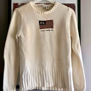 Vintage Ralph Lauren  - Vintage tröja från Polo Jeans Ralph Lauren. Beige/vit stickad tröja med amerikanska flaggan, samt polos klassiska signatur RL inbroderat. Perfekt till hösten/vinterns mys.  Strl M