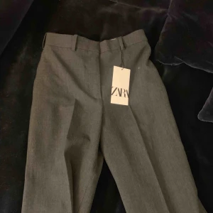  - Lång kostymbyxa i grått. Nypris 549:- Oanvända med  lappen kvar.