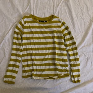 Gulvit randig långärmad tröja  - Långärmad, hyfsat tunn långärmad tröja i senapsgul och vit. Tröjan är använd max 2 ggr och är från Lager 157. Storleken säger S men skulle säga att den mer är M