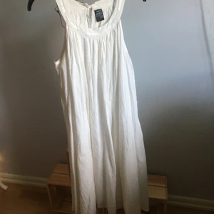 Vit klänning från ellos/pinky  - Vit klänning som går ganska högt i halsen. Knapp i nacken. Paljett detaljer i halsen. Inga armar. Bra skick. 