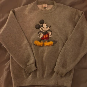 Grå Mickey Mouse collegetröja  - Super snygg grå mickey mouse collegetröja från Disney store. Super bra skick och är i storlek S. Köpare står för frakt <3