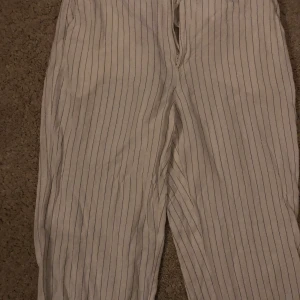 Randiga kostymbyxor  - Vita kostymbyxor med ränder. Strl 38. 