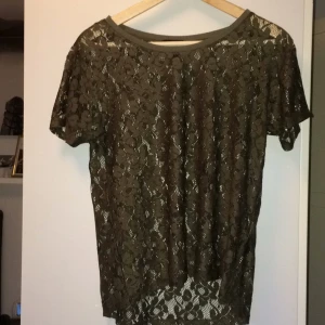  - Superskön T-shirt från HM. Khakigrön, nästan lite skimrande. Passar bra med ett linne eller T-shirt under. Väldigt skön, perfekt vardagsplagg. Knappt använd, fint skick! Köparen betalar frakt!