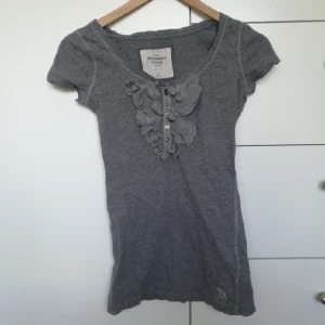  - Snygg och skön t-shirt från Abercrombie. Säljer på grund av att jag inte använder den. Den har några pyttesmå hål längst ner men det är inget som syns när man har den på. Kan mötas upp i centrala Stockholm eller posta (köparen betalar frakten).