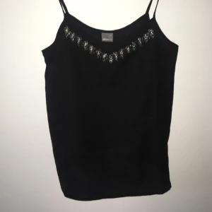  - Väldigt fint linne. Funkar lika bra på festen som i veckan. Vanligt svart, men med väldigt snygg detalj i urringningen. Köparen får stå för frakten.  