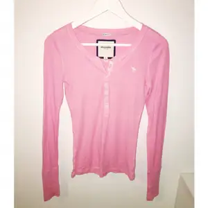 Långärmad tröja i ljust rosa från Abercrombie & Fitch, passar från en XS-M i och med stretch. Strl kids XL. Bruksskick.