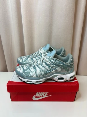 Nike TN ”palm” - Nike Air Max Plus sneakers i ljusblått och vitt med unikt mönster på ovandelen. Skorna har synliga Air Max-enheter i sulan, vita snören och detaljer i syntetmaterial. Swoosh-logga på sidan och TN-logga bak. Perfekta för dig som gillar statement sneakers.