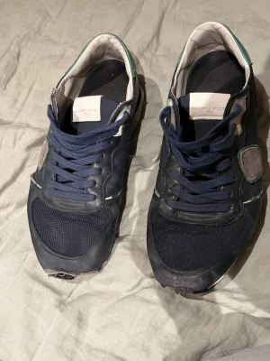 Philippe Model blå sneakers - Mörkblå sneakers från Philippe Model med detaljer i mocka och skinn, vita och gröna inslag samt blå snörning.  Pris går och diskutera!!