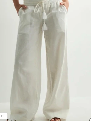 Vita vida linnebyxor med snörning - Säljer ett par luftiga och sköna vita linne byxor! Aldrig använts därför säljer jag de. 