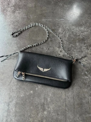 Svart axelväska från Zadig & Voltaire - Svart handväska Zadig & Voltaire köpt på NK. Material grained leather. Superfin, använd endast ett par gånger. Dustbag medföljer. Mått 27 x 13 x 2 cm.