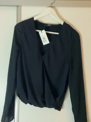 Svart V-ringad blus  - V ringad svart långärmad blus från bikbok med original prislapp.