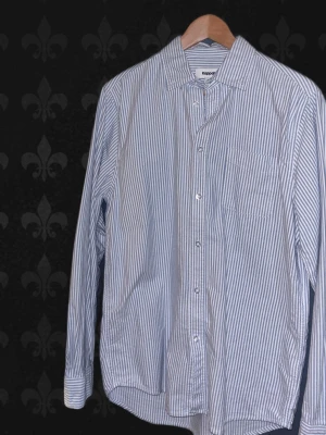 Randig skjorta från Kappahl, S - Säljer en klassisk vit och blå randig skjorta från Kappahl i storlek S. Skjortan har långa ärmar, bröstficka och knappar framtill. Tillverkad i mjuk bomull som känns skön mot huden. Perfekt till jeans eller chinos för en clean look.