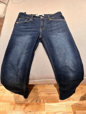 Levi's 512 slim taper jeans. - Passar dig som är cirka 176cm lång. Klassiska Levi's 512 slim i mörkblå tvätt med raka ben och femficksmodell. Snygga kontrastsömmar och ikonisk läderpatch bak i midjan. Jeansen är tillverkade i slitstarkt denim och har knappgylf. Perfekta för dig som gillar tidlös stil.