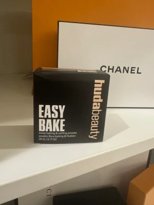 Huda Beauty Easy Bake Pound Cake puder - Loose baking & setting powder i nyansen Pound Cake från Huda Beauty. Kommer i en svart och beige förpackning, 20g. Pudret håller sminket på plats, absorberar glans och ger ingen flashback. Perfekt för att fixera makeup och få en matt finish.