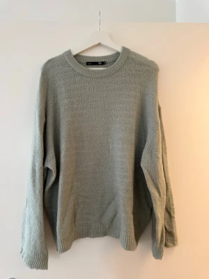 Ljusgrön stickad tröja från 157 - Mysig ljusgrön stickad tröja från 157 med rund halsringning och ribbade muddar vid ärmslut och nederkant. Perfekt för lager på lager under kyliga dagar. Enkel och clean design som funkar till allt. Lite oversize 