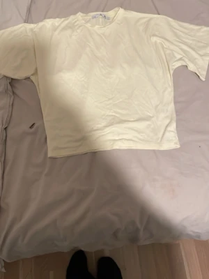 Vit basic t-shirt i bomull - Enkel och stilren vit t-shirt med klassisk passform och rund hals. T-shirten är kortärmad och gjord i mjuk bomull, perfekt för en clean och avslappnad look. Passar till allt och är ett måste i garderoben.