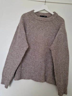 Beige - brun stickad tröja från Lager 157 - Mysig beige/brun stickad tröja från Lager 157 i storlek L. Tröjan har grov ribbstickning, rund halsringning och långa ärmar. Perfekt för lager på lager under kyliga dagar och ger en avslappnad vibe till din outfit. Fint skick, inte nopprig. Varm och mysig