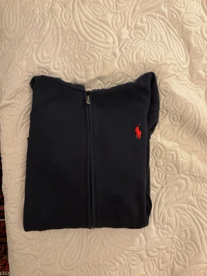 Ralph Lauren helzip – Storlek M - 👕 Ralph Lauren helzip – Storlek M  Säljer en Ralph Lauren helzip i mörk färg, klassisk och stilren modell ✅ Smidig dragkedja och skön kvalitet som passar perfekt som lager-på-lager ✅ Funkar lika bra till vardags som till en mer uppklädd look ✅  Storlek: M ✅ Pris går såklart att diskutera vid snabb affär ✅ Hör av dig vid frågor eller intresse  