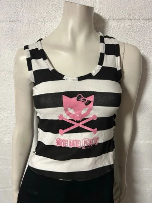 Linne Bye bye Kitty med säkerhetsnålar insidorna. S/M - Helt nytt linne med Kitty. Storlek S/M. Material i Stretchig bomullstrikå. 