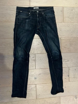 Mörkblå Acne jeans Max Soft Raw 31/34 - Säljer ett par mörkblå jeans från Acne i modellen Max Soft Raw. Klassisk femficksdesign, raka ben och snygga kontrastsömmar. Tillverkade i 99% bomull och 1% elastan för lite stretch. Perfekta för dig som gillar stilrena och tidlösa jeans.