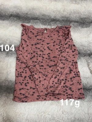 Rosa prickig långärmad topp - Säljer en rosa långärmad topp med prickar och volangdetaljer på axlarna. Toppen har rund halsringning. Perfekt för dig som gillar lekfulla mönster och snygga detaljer.🌸 Fint använt skick. Storlek 104