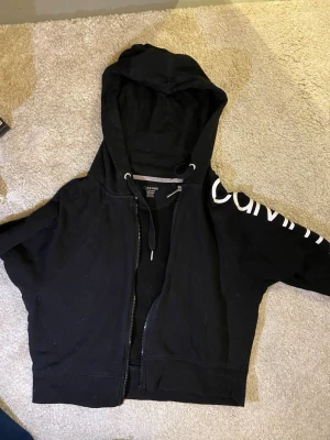 Svart hoodie från Calvin Klein - Supersnygg svart hoodie från Calvin Klein med dragkedja och snören vid halsen. Passar perfekt med ett par jeans att ha på en vardag. Jag säljer den pågrund av att den inte passar min stil längre❤️