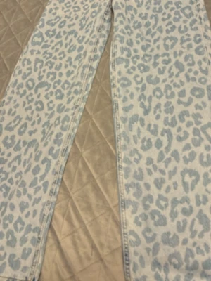 Leopardmönstrade ljusblå jeans - Säljer ett par unika ljusblå jeans med leopardmönster. Byxorna har klassisk femficksdesign och raka ben. Materialet är kraftigt jeans och färgtonen är ljusblå med gråblått mönster. Perfekta för dig som vill sticka ut med din stil.