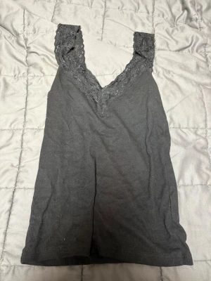 Svart spetsdetaljerad linnetopp - Säljer en svart linnetopp från mywear woman i storlek S. Toppen har breda axelband med fina spetsdetaljer och en v-ringad urringning framtill. Materialet är mjukt och stretchigt