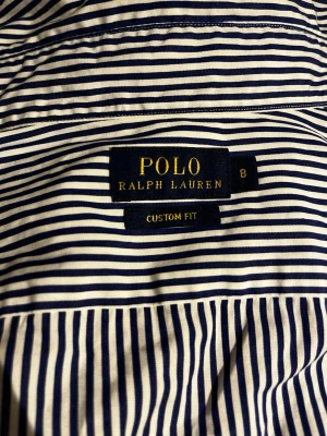 Randig skjorta från Polo Ralph Lauren - Säljer en klassisk blåvit randig skjorta från Polo Ralph Lauren, custom fit. Säljer då den inte passar mig! Använt fåtal gånger skick:8/10! Pris:399kr