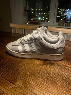 Gråa Adidas campus  - Säljer ett par grå Adidas Campus i mycket bra och fräscht skick! De är i ett hållbart mocka material med en gummi sula. Skorna är i storleken 42 2/3 och passar dig som gillar en avslappnad stil! Hojta till vid frågor eller funderingar! Skickar inom 24h.