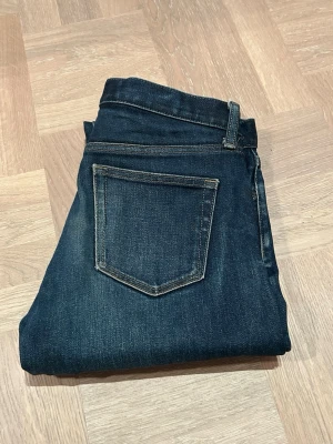 Jeans Uniqlo - Snygga mörkblå jeans med klassisk femficksdesign och kontrastsömmar. Modellen har en rak passform och feta fades. Hör av dig vid funderingar! 