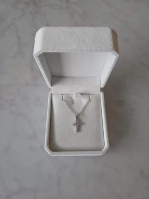 Halsband med kors - Ett fint halsband med ett kors som hänge. Halsbandet är jätte fin.