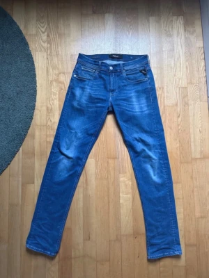 Replay Grover Hyperflex jeans blå - Säljer ett par Replay Grover Hyperflex jeans i klassisk blå färg. De har fem fickor, snygga sömmar och en liten Replay-logga vid fickan. Jeansen är raka i modellen och har en bekväm stretchig känsla tack vare Hyperflex-materialet.