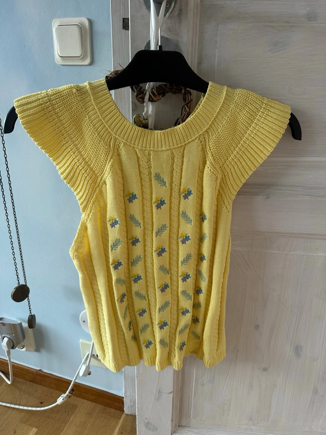 Gul stickad ärmlös tröja med blommor
