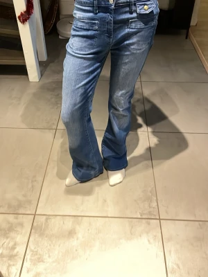 Blå bootcut jeans med fickdetaljer - Snygga blå flare jeans. Dom är W27 och L32! Dom är också ganska töjbara så de passar bäst för xs och s