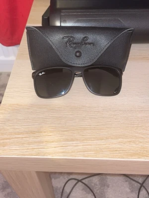 Svarta glasögon från Ray-Ban - Säljer ett par svarta solglasögon från ray-ban. Den kommer med en fodral till den och Dom är väldigt stiliga, Dom passar väldigt fin i sommaren men de används som du vill.