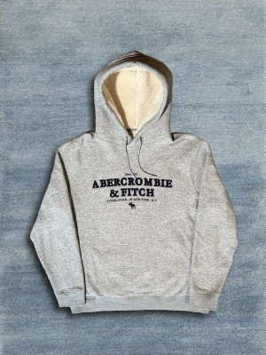 Abercrombie & Fitch Hoodie - En grå hoodie med skön fodring ifrån Abercrombie & Fitch. Den är som ny i skicket. Hör av dig vid frågor eller fler bilder!🙌