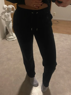 Juicy Couture byxor svarta med knappar bak - Svarta mjukisbyxor från Juicy Couture. Med knappar där bak. Går att köpa kofta till! Skriv >>