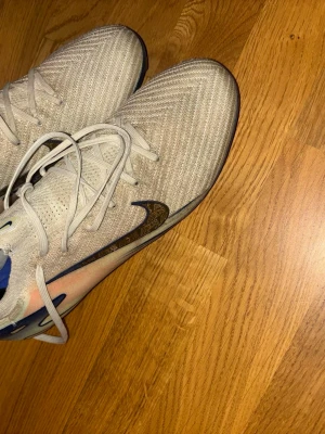 Nike Air Zoom fotbollsskor beige - Säljer ett par Nike Air Zoom fotbollsskor elite såklart , fick dem av Sebastian tounekti som spelade i Hammarby 2025 