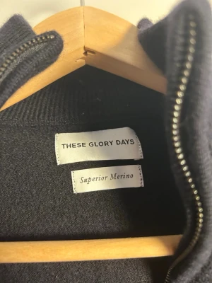 Mörkblå merinoullskofta These Glory Days - Säljer en mörkblå kofta från These Glory Days i Superior Merino. Koftan har hel dragkedja framtill, ribbade muddar och lång ärm. Perfekt för dig som gillar stilrena och bekväma plagg i merinoull. Har krymp i tvätten passar mer xs 