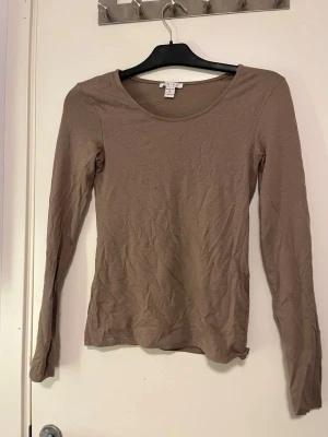 Beige långärmad topp från Amisu - En enkel och stilren beige långärmad topp från Amisu. Modellen har rund halsringning och är figurnära i passformen. Perfekt att matcha med jeans eller kjol för en clean look. Använd fåtal gånger. Pris kan alltid diskuteras!🤗